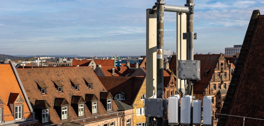 Mobilfunkantenne auf einem Hausdach in einer historischen Altstadt.