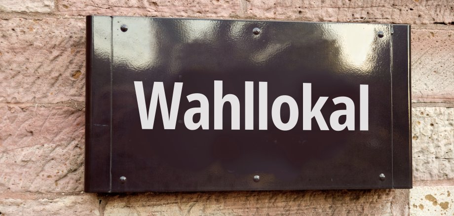 Schild "Wahllokal" an einer Hauswand