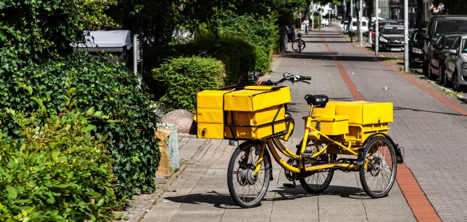 Postfahrrad Briefträger bei der Zustellung