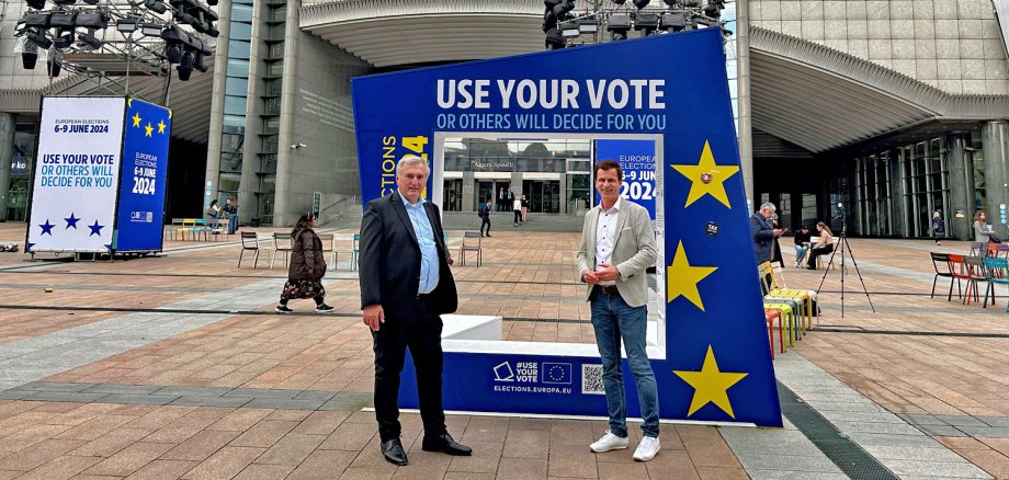 Besuch von DStGB-Hauptgeschäftsführer Dr. André Berghegger in Brüssel vor der Europawahl. Vor einem Plakat mit der Aufforderung zur Wahl zu gehen.
